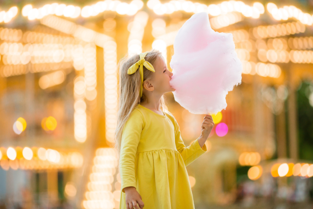 Little,Girl,On,A,Walk,In,An,Amusement,Park,Eating